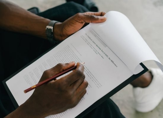 Close-up of a person writing on a psychological assessment form with a pencil.